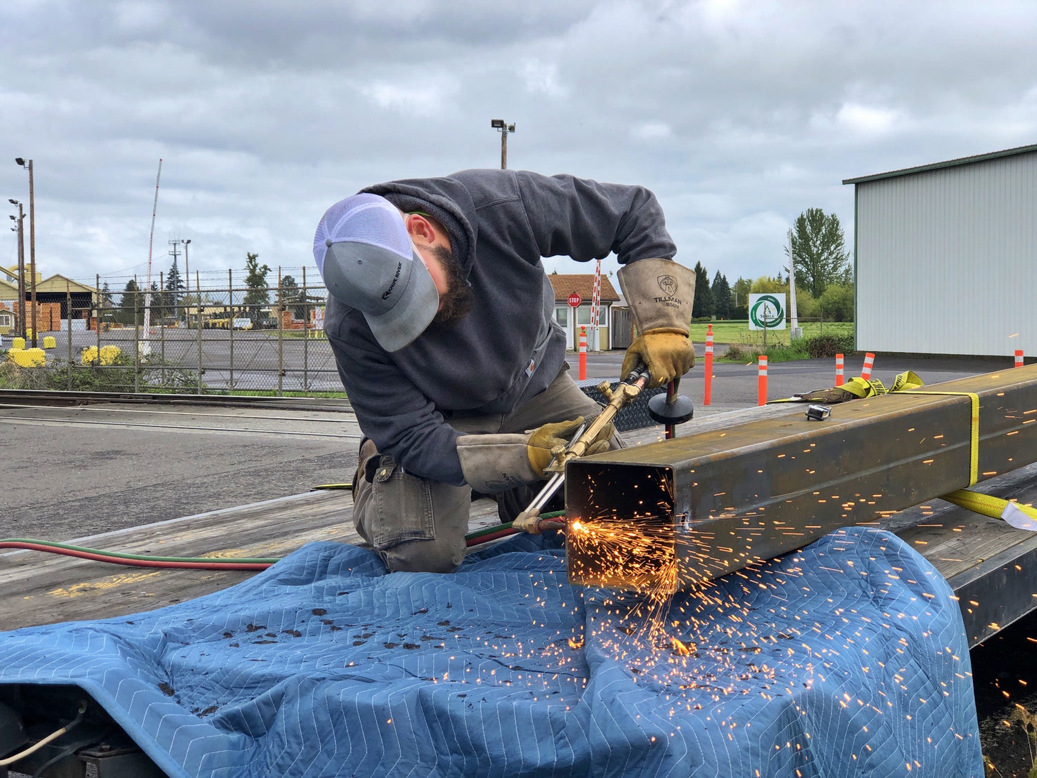 Man with torch cutting steel beam